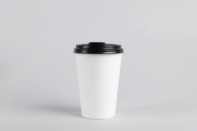 Paper cup with plastic lid on light background. Coffee to go