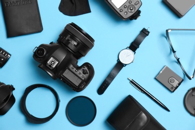 Flat lay composition with professional photographer equipment and accessories on color background