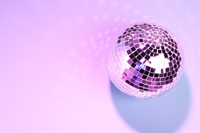 Photo of Shiny disco ball on color background. Space for text