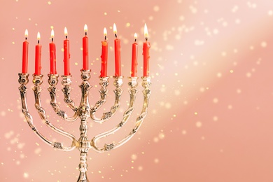 Menorah with burning candles on color background, space for text. Hanukkah celebration