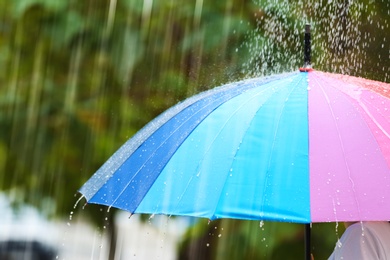 Photo of Person with bright umbrella under rain on street, closeup