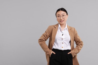 Photo of Portrait of smiling businesswoman on grey background. Space for text