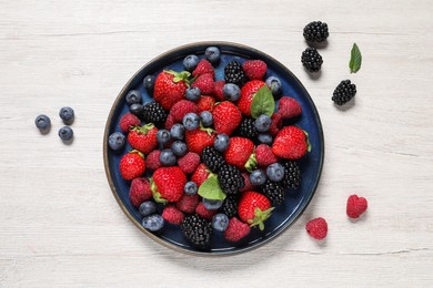 Photo of Different fresh ripe berries on light wooden table, flat lay