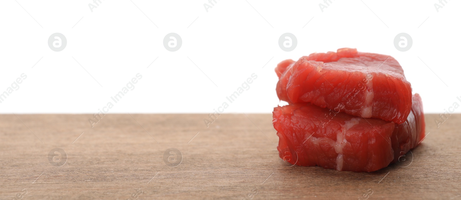 Photo of Pieces of raw cultured meat on wooden table against white background, space for text