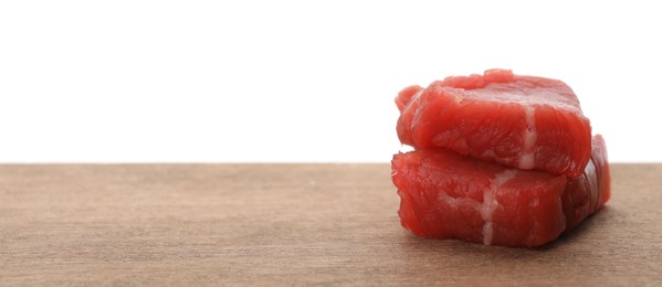 Photo of Pieces of raw cultured meat on wooden table against white background, space for text