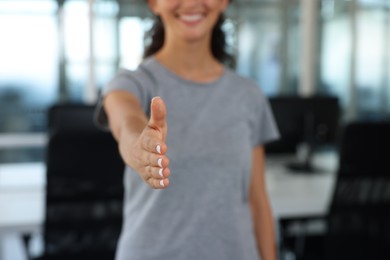 Photo of Woman welcoming and offering handshake indoors, closeup. Space for text