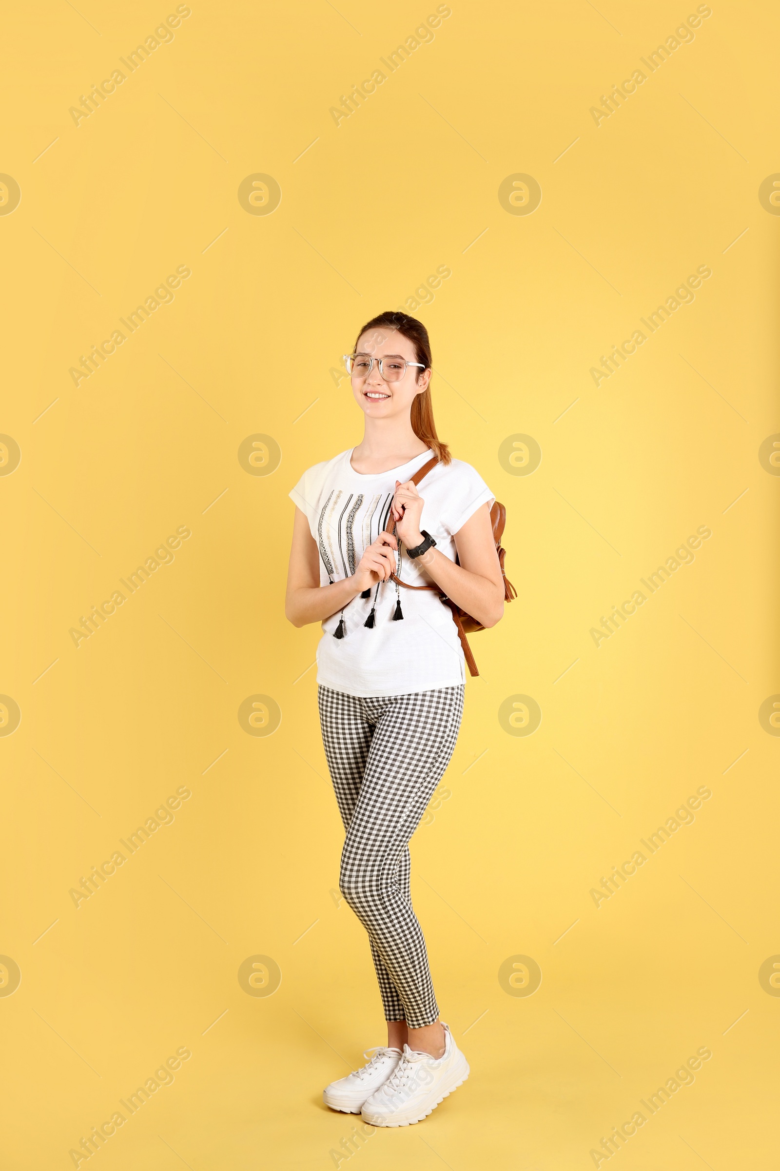 Photo of Teenage girl with backpack on color background