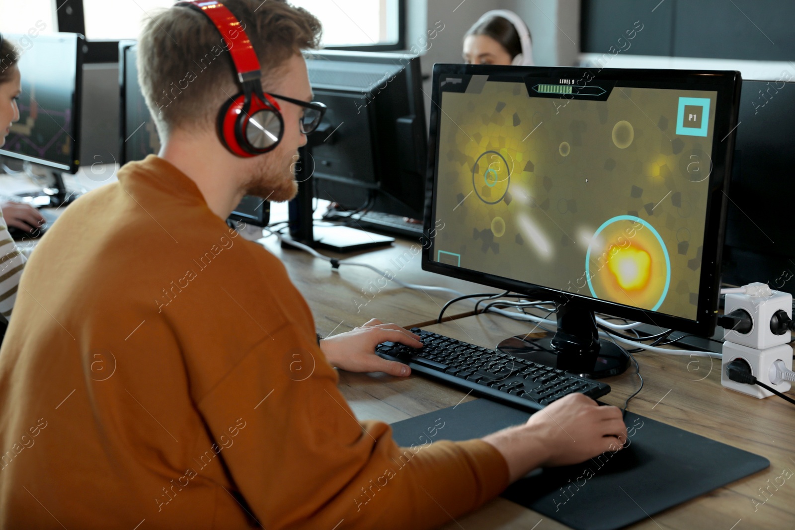 Photo of Man playing video game in internet cafe