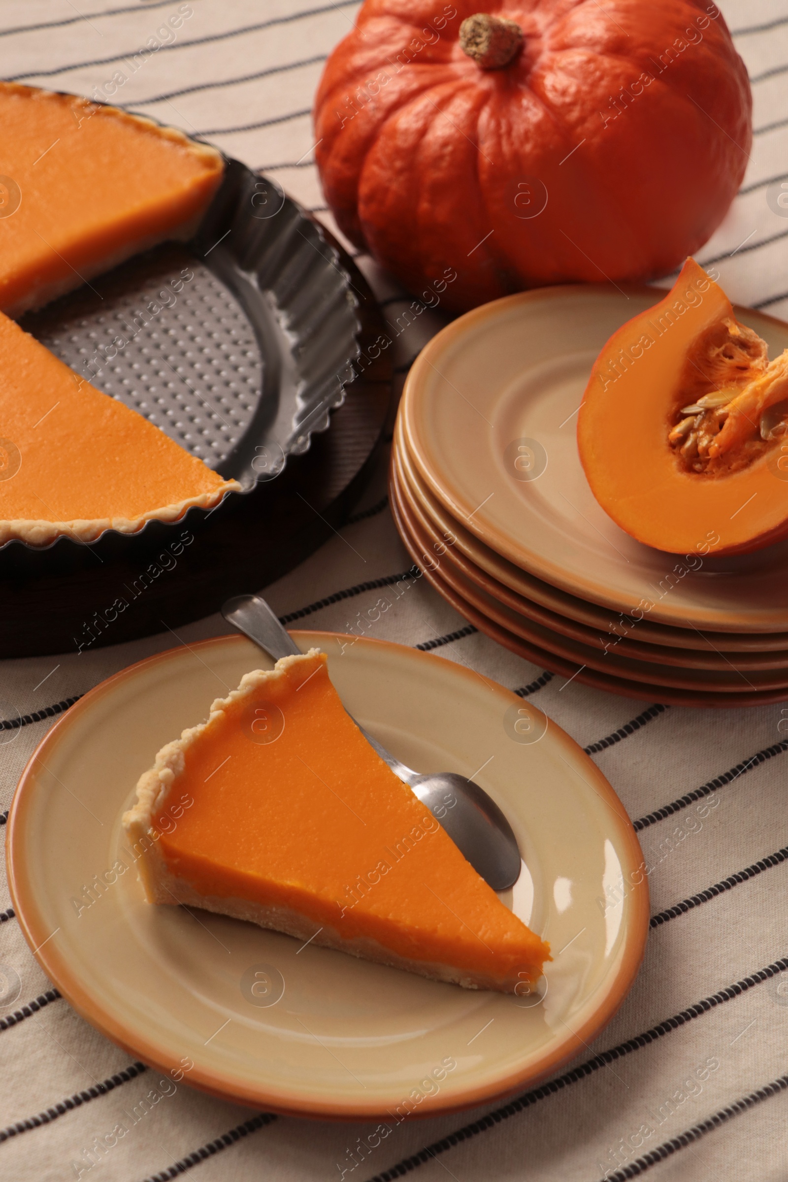 Photo of Plate with piece of homemade pie and fresh pumpkin on table