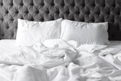 Photo of Comfortable bed with white linen and pillows at home