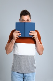 Photo of Handsome man with book on light background. Reading time