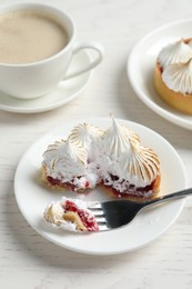 Tartlet with meringue served on white wooden table. Delicious dessert