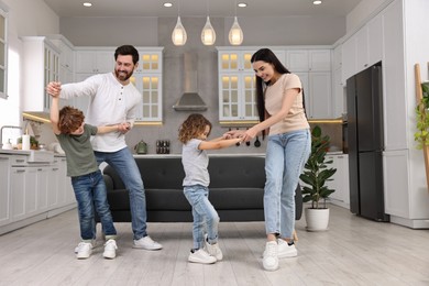 Happy family dancing and having fun at home, low angle view