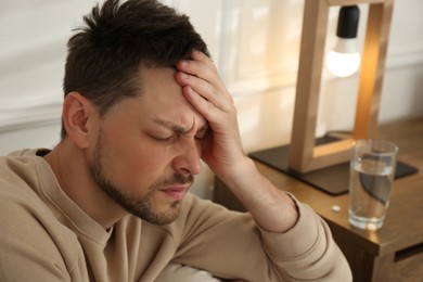 Photo of Man suffering from terrible migraine at home