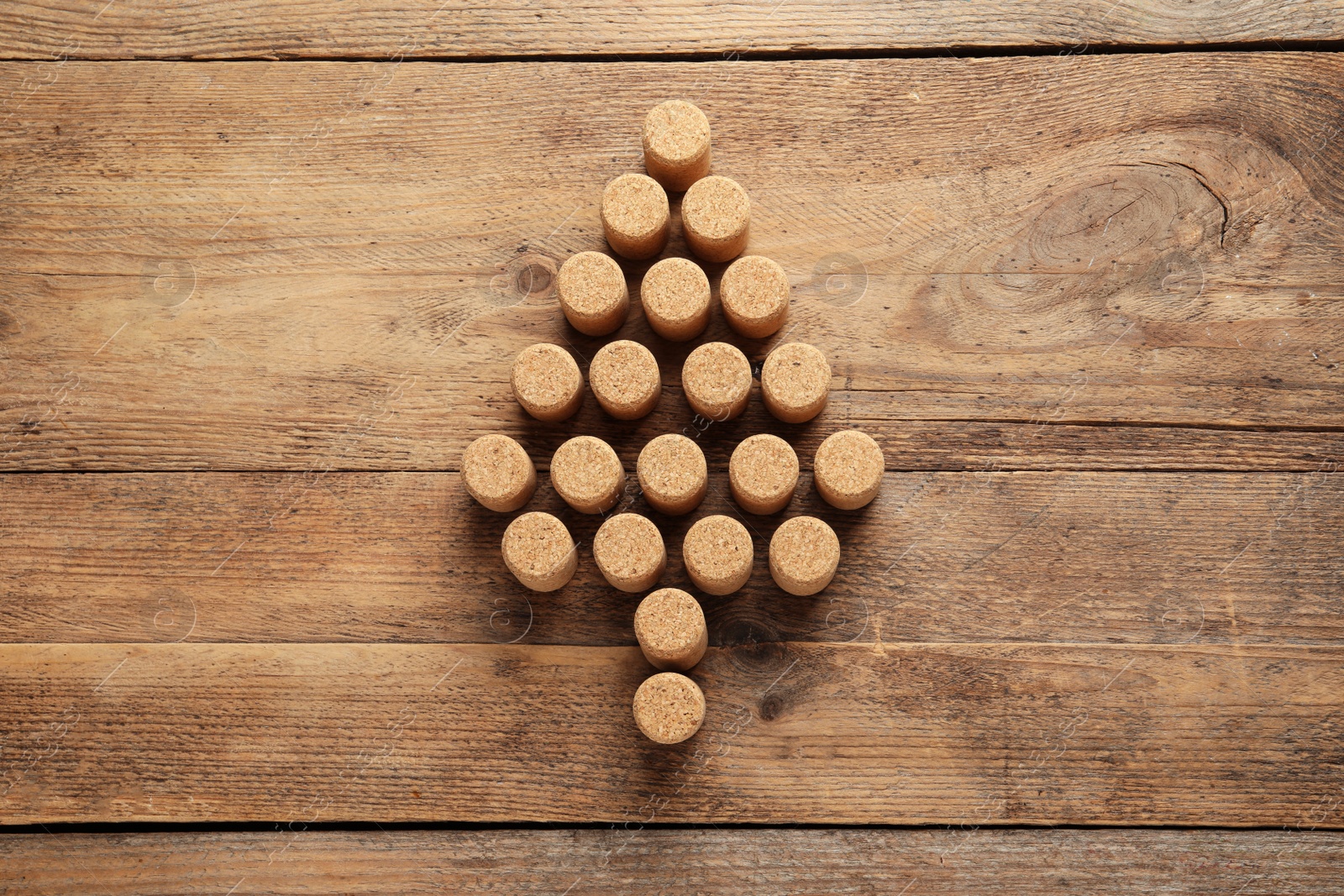 Photo of Christmas tree made of wine corks on wooden table, top view