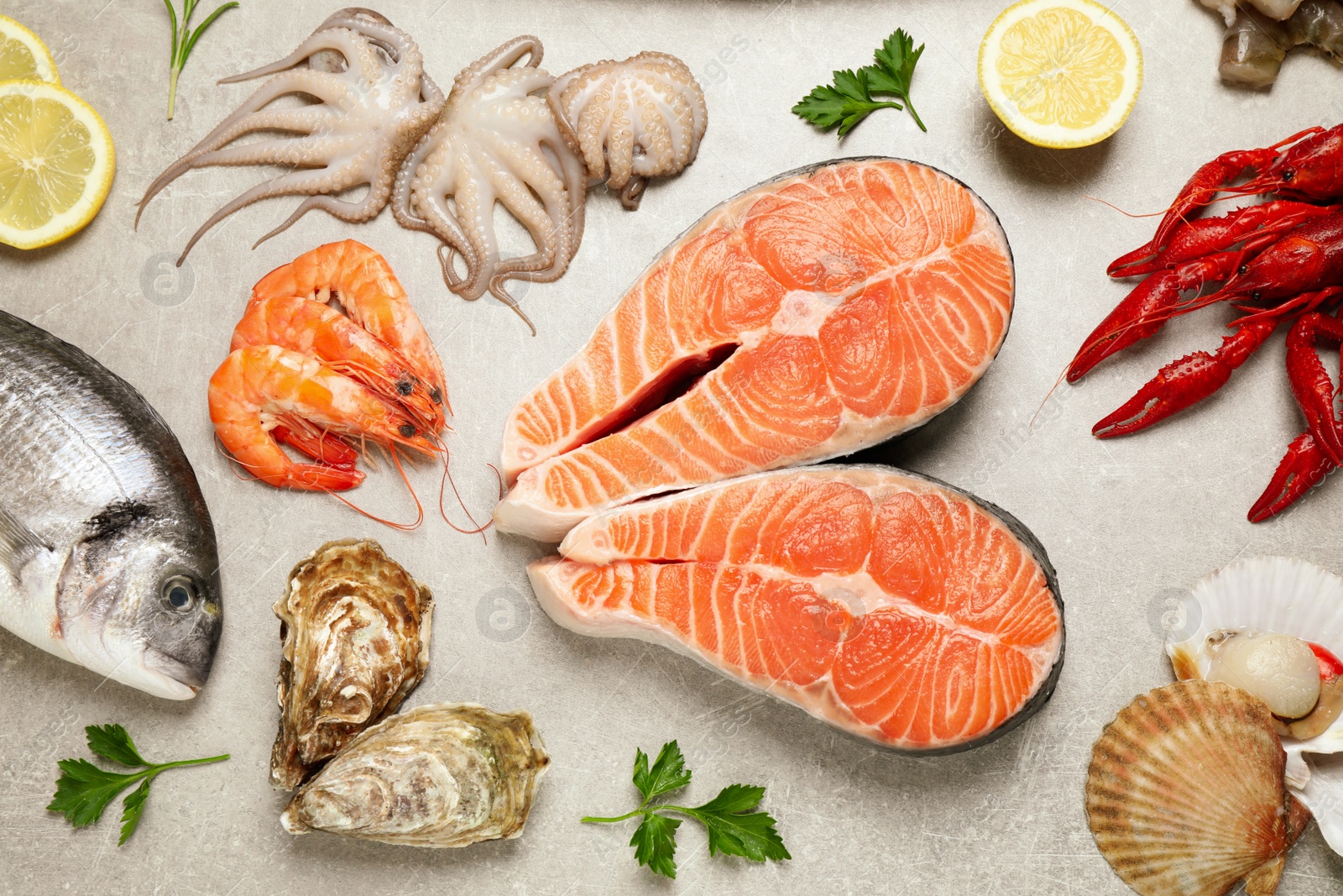 Photo of Fresh fish and seafood on light grey table, flat lay