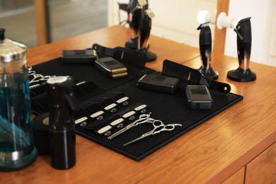 Stylish hairdresser's workplace with professional tools and cosmetic products in barbershop