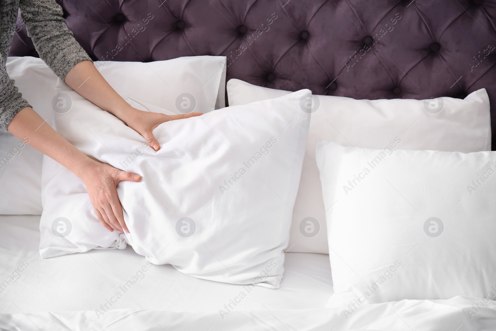 Photo of Young woman making bed, closeup