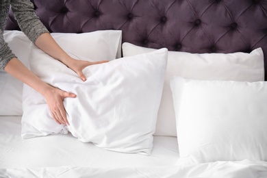 Young woman making bed, closeup