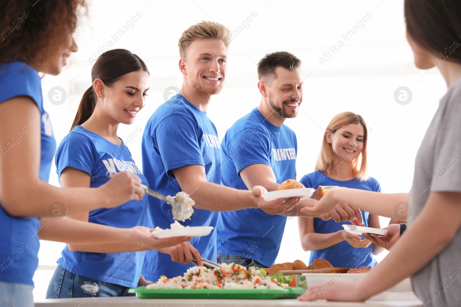 Photo of Volunteers serving food to poor people indoors