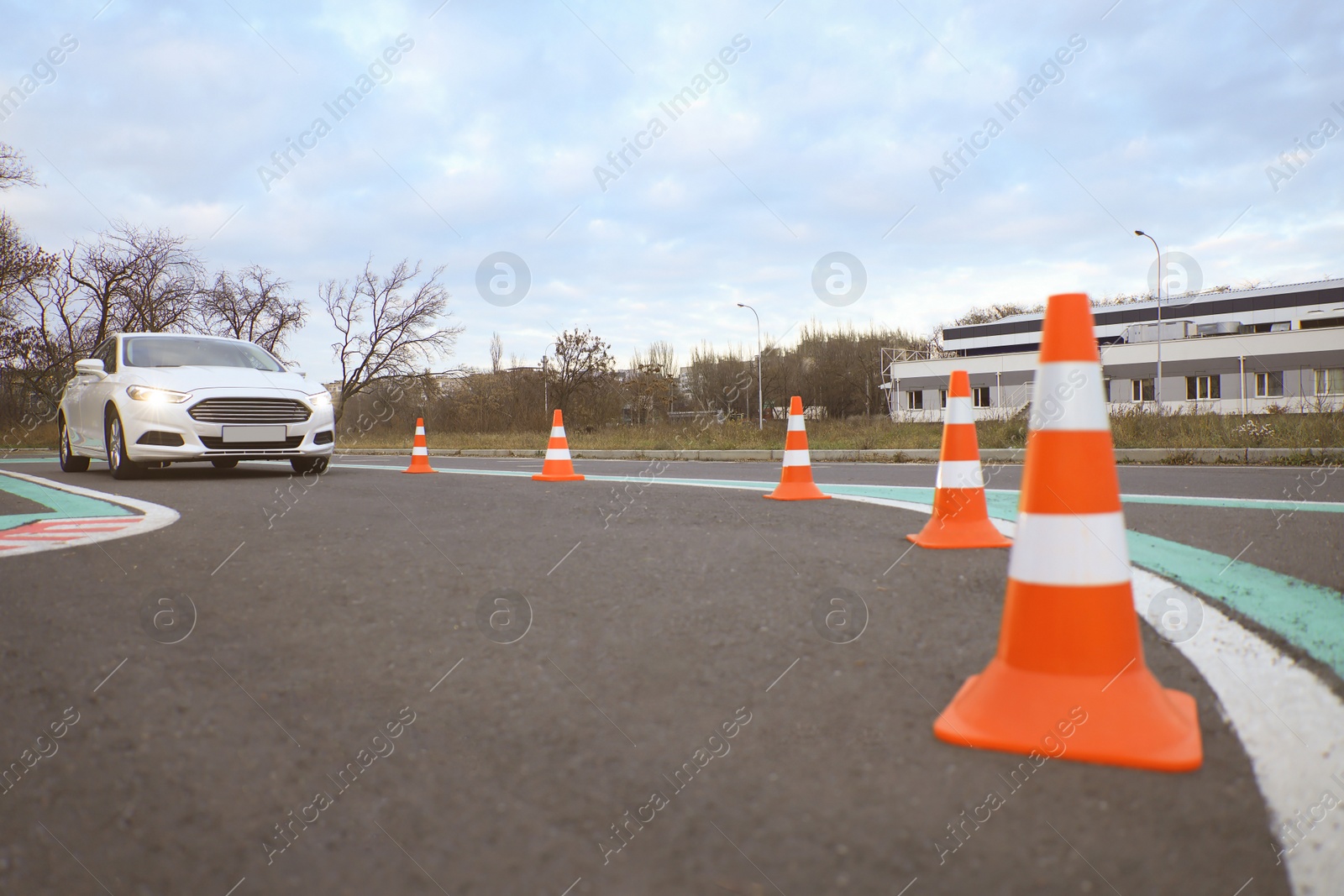 Photo of Modern car on driving school test track with traffic cones