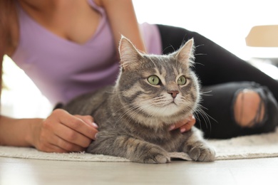 Photo of Young woman with cute cat at home, closeup. Pet and owner