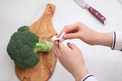 Photo of Woman cut finger while cooking at table, above view