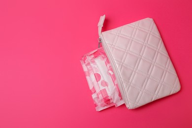 Photo of White bag with menstrual pads on pink background, top view. Space for text