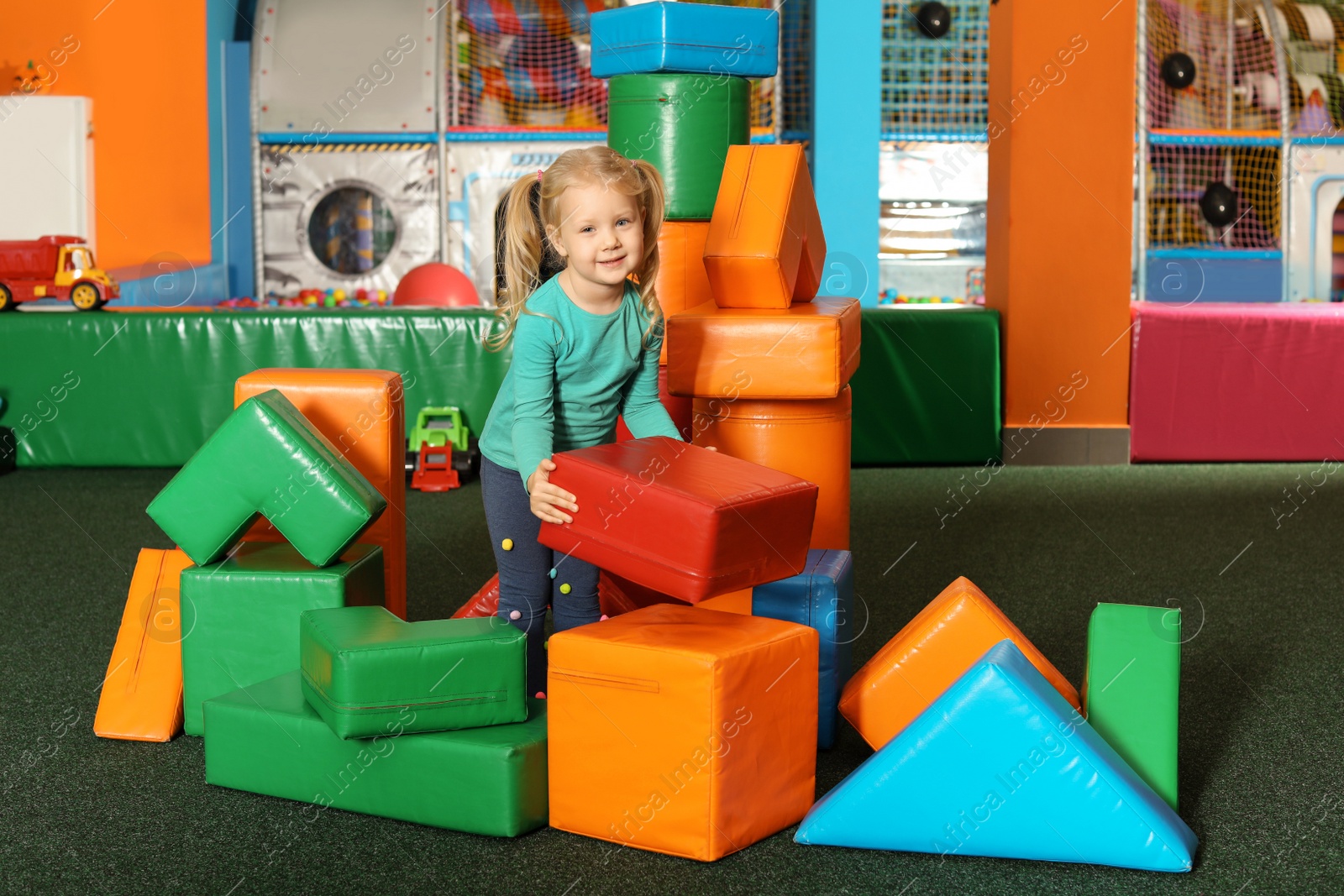 Photo of Cute child playing with colorful building blocks indoors