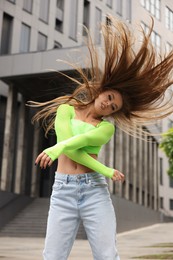 Beautiful young woman dancing hip hop outdoors