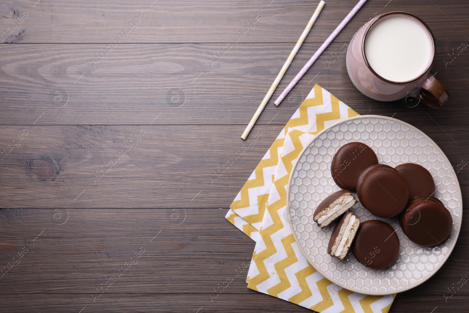 Photo of Tasty choco pies and milk on wooden table, flat lay. Space for text
