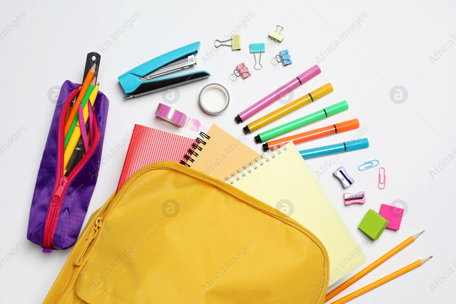 Photo of Backpack with different school stationery on white background, flat lay