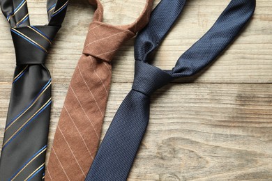 Photo of Different neckties on light wooden table, flat lay. Space for text