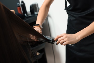 Hairdresser working with client in beauty salon, closeup