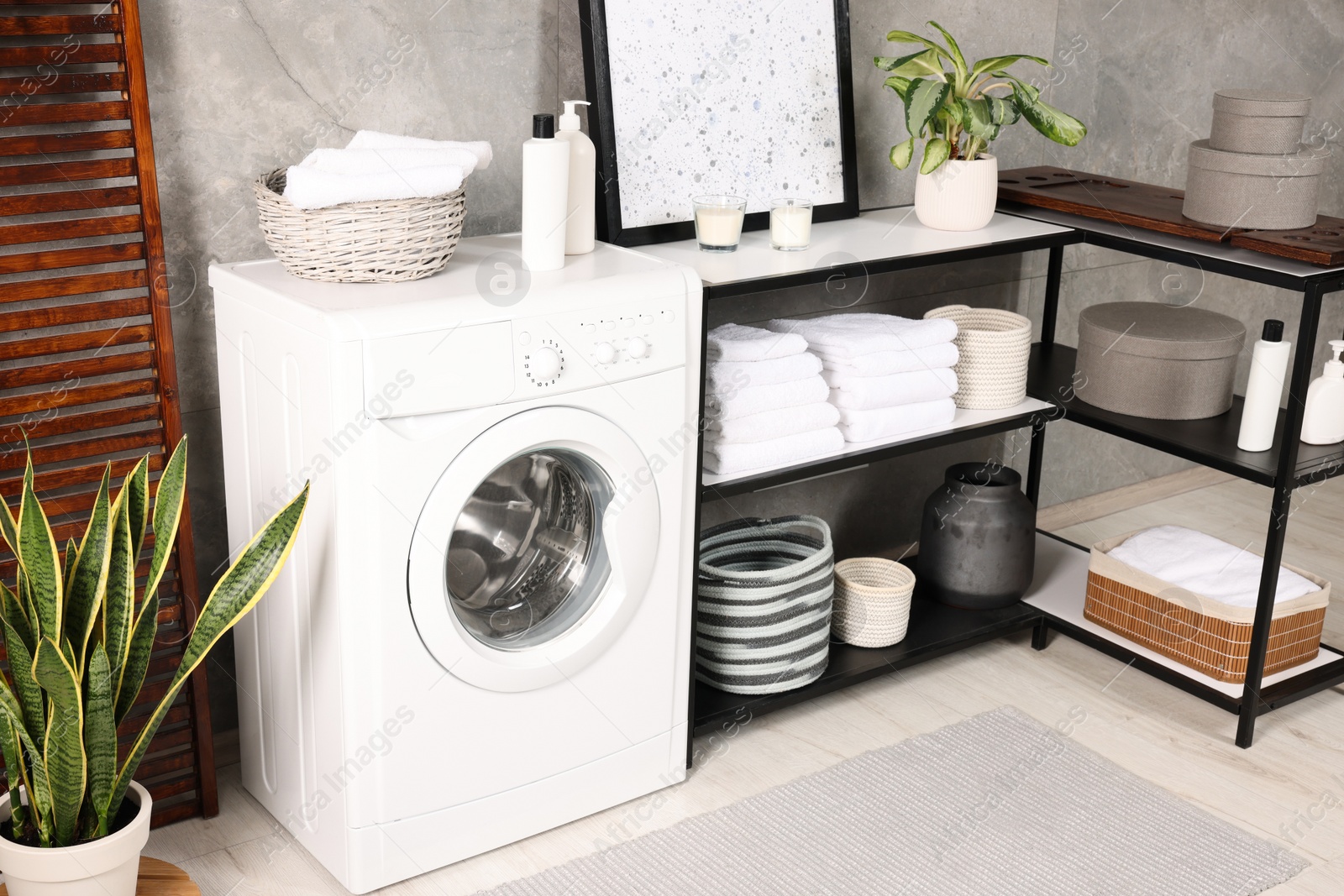 Photo of Stylish laundry room with modern washing machine. Interior design