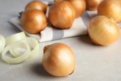 Photo of Ripe onions and rings on grey table