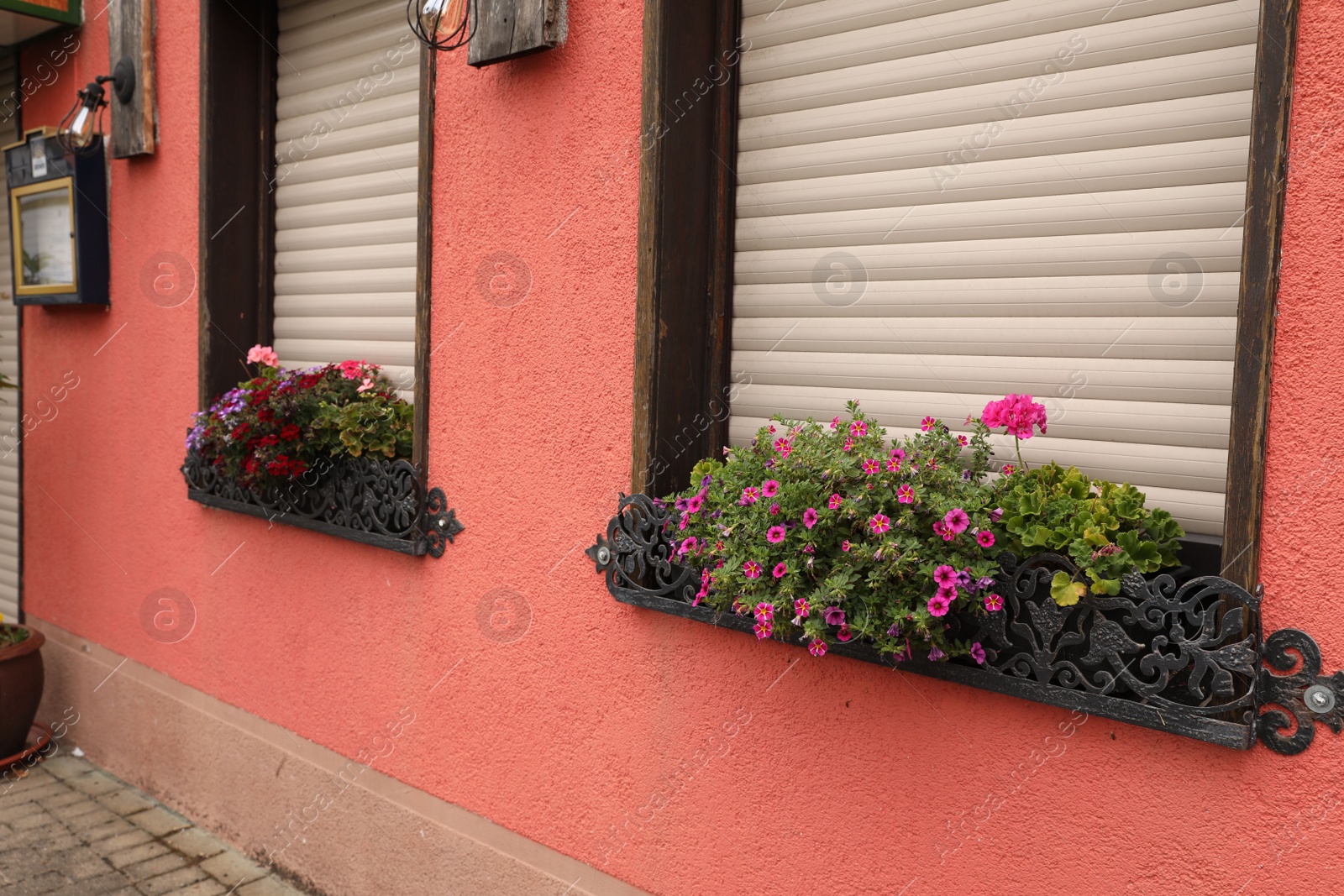 Photo of Exterior of beautiful apartment building with flowers on windowsills