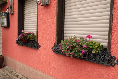 Exterior of beautiful apartment building with flowers on windowsills