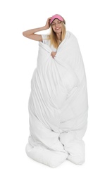 Photo of Young woman in sleeping mask wrapped with soft blanket on white background