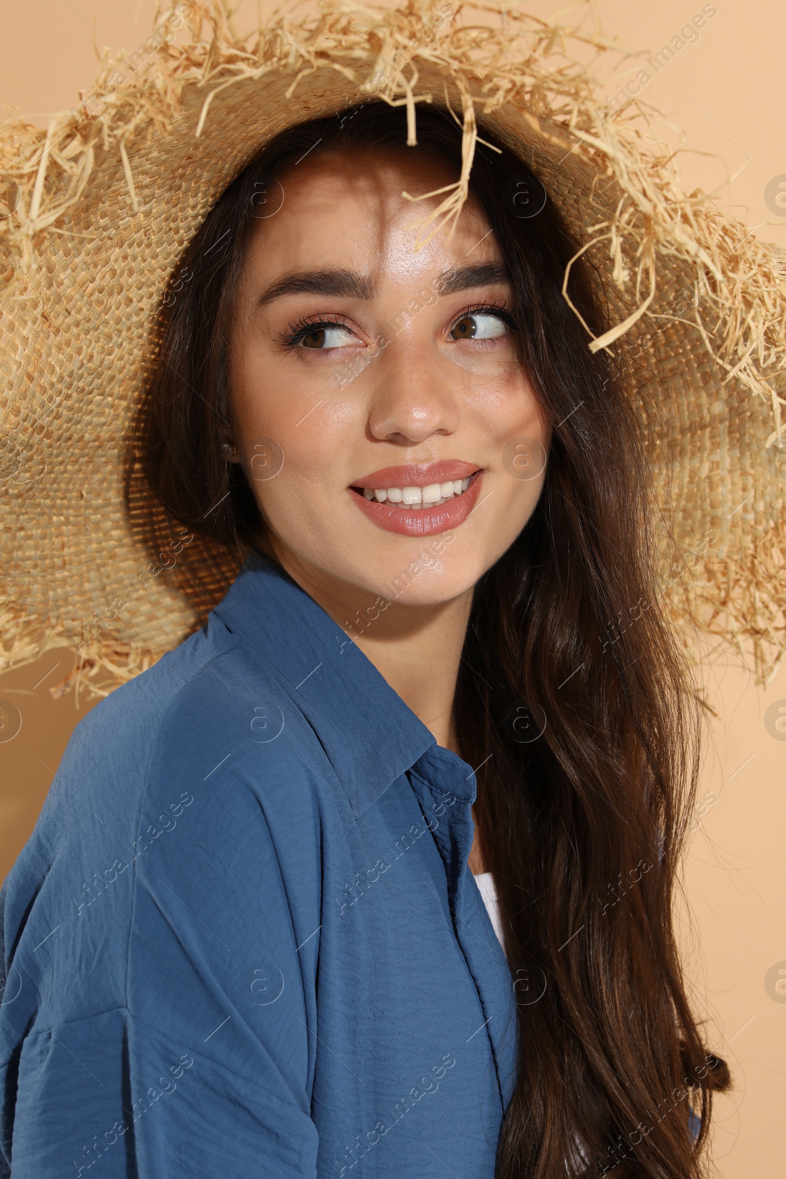 Photo of Young woman in straw hat on beige background