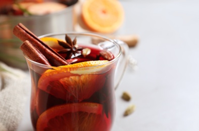 Glass cup of tasty mulled wine on grey table, closeup