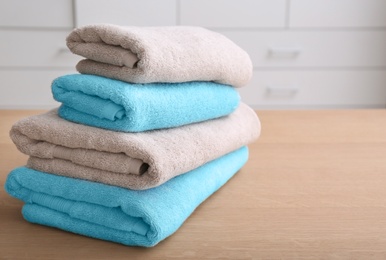 Stack of clean towels on table indoors