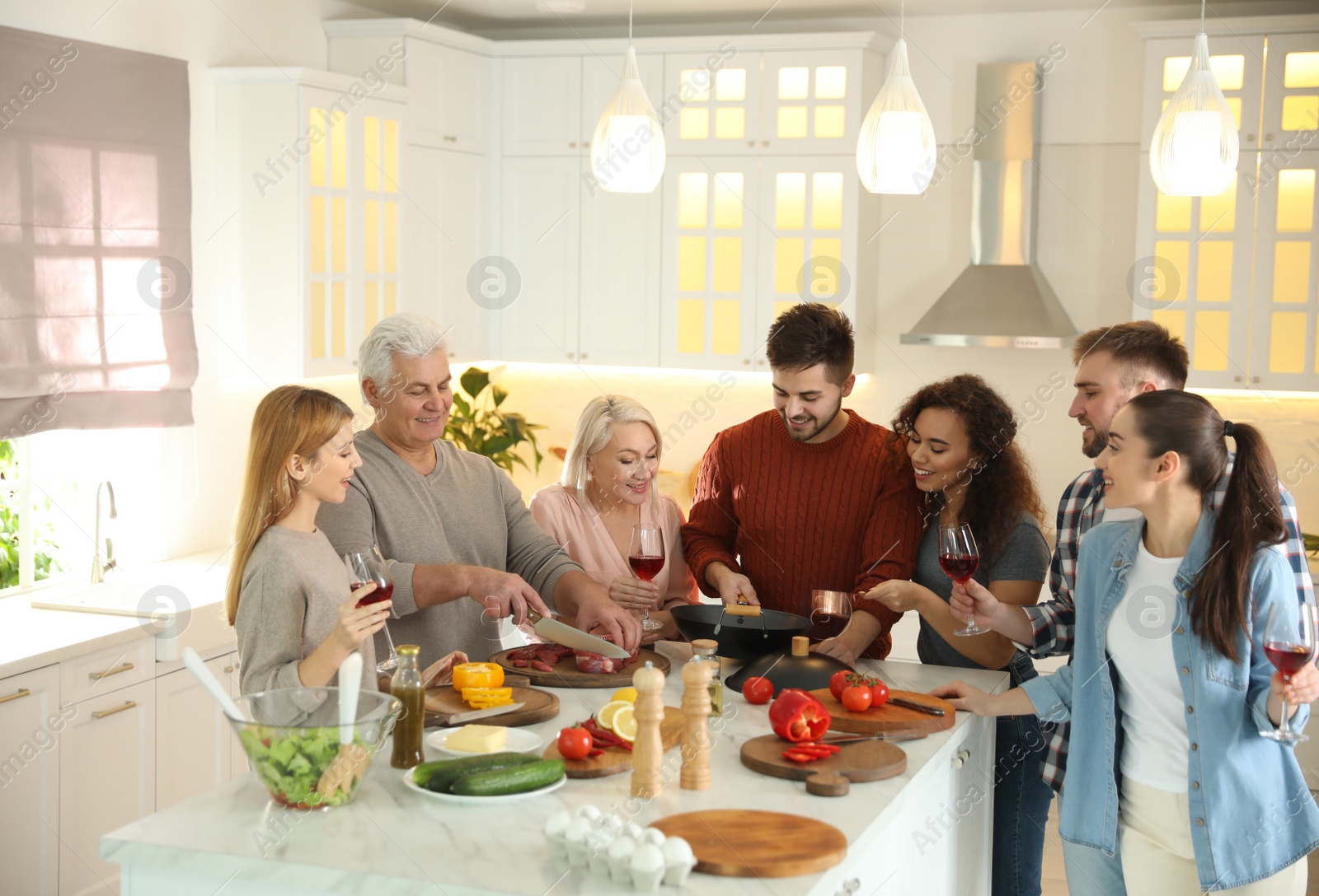 Photo of Happy people cooking food together in kitchen