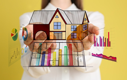 Image of Designer presenting project of house with charts on yellow background