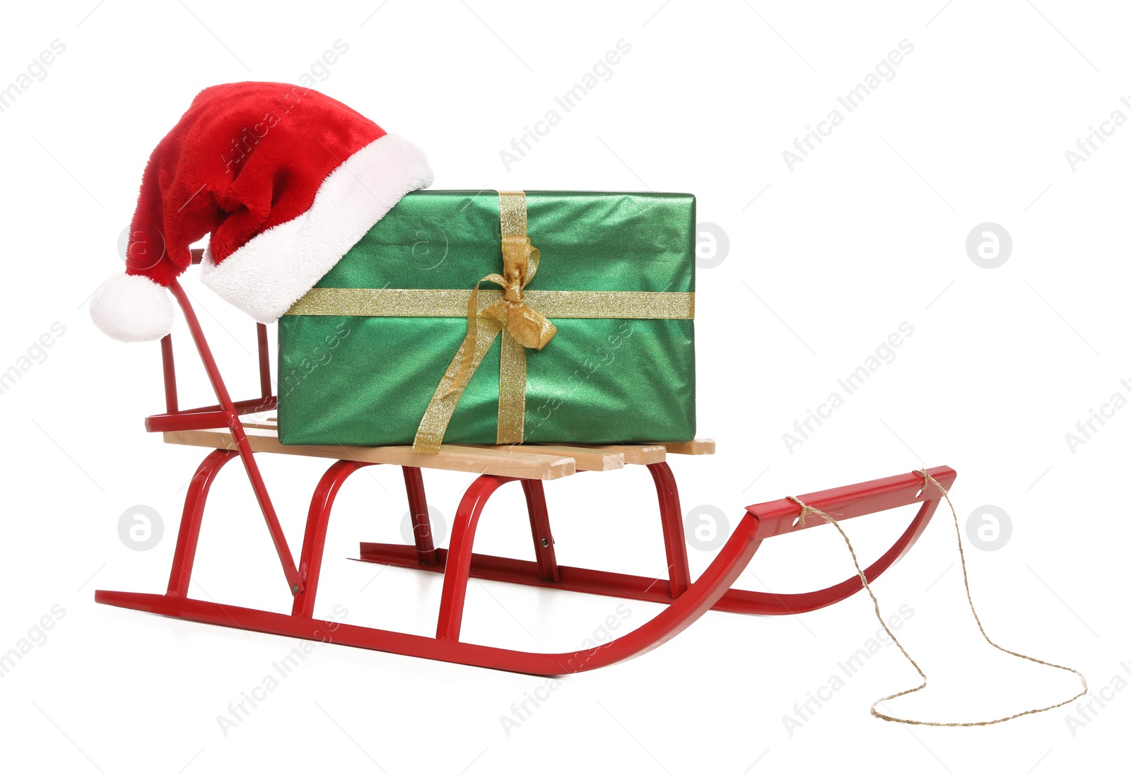 Photo of Sleigh with green gift box and Santa hat isolated on white