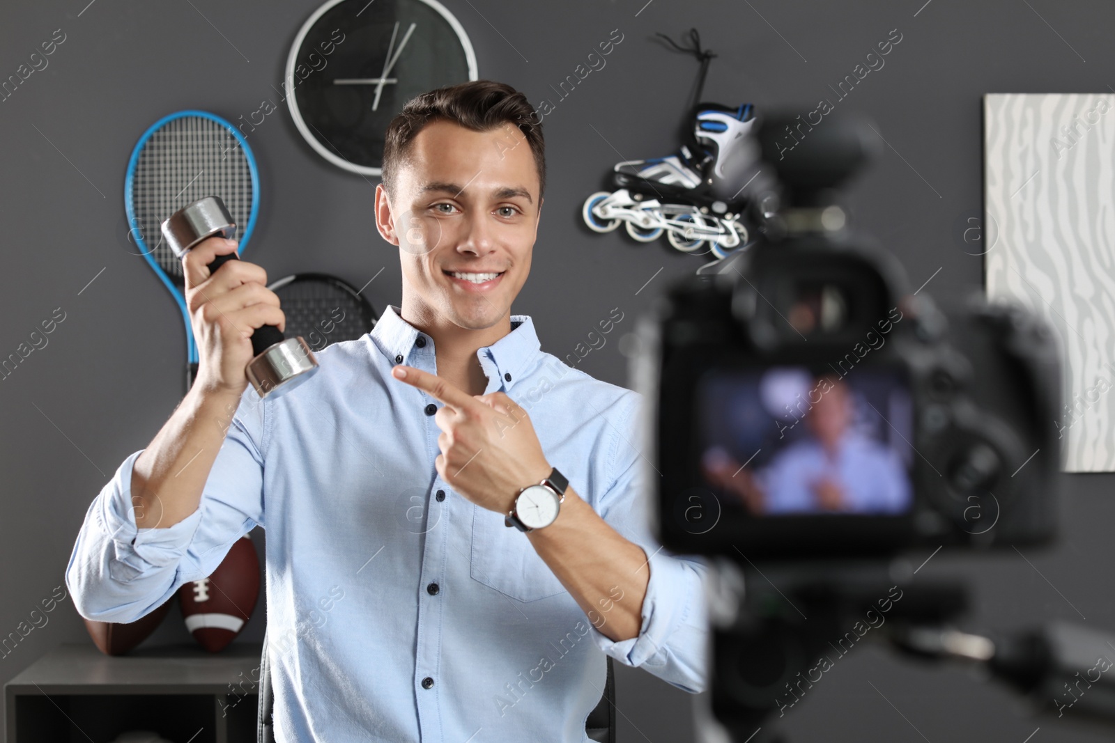 Photo of Sport blogger recording video on camera indoors