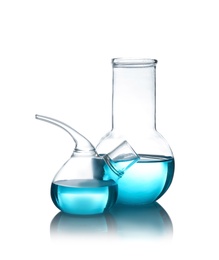 Laboratory glassware with liquid on table against white background. Chemical analysis