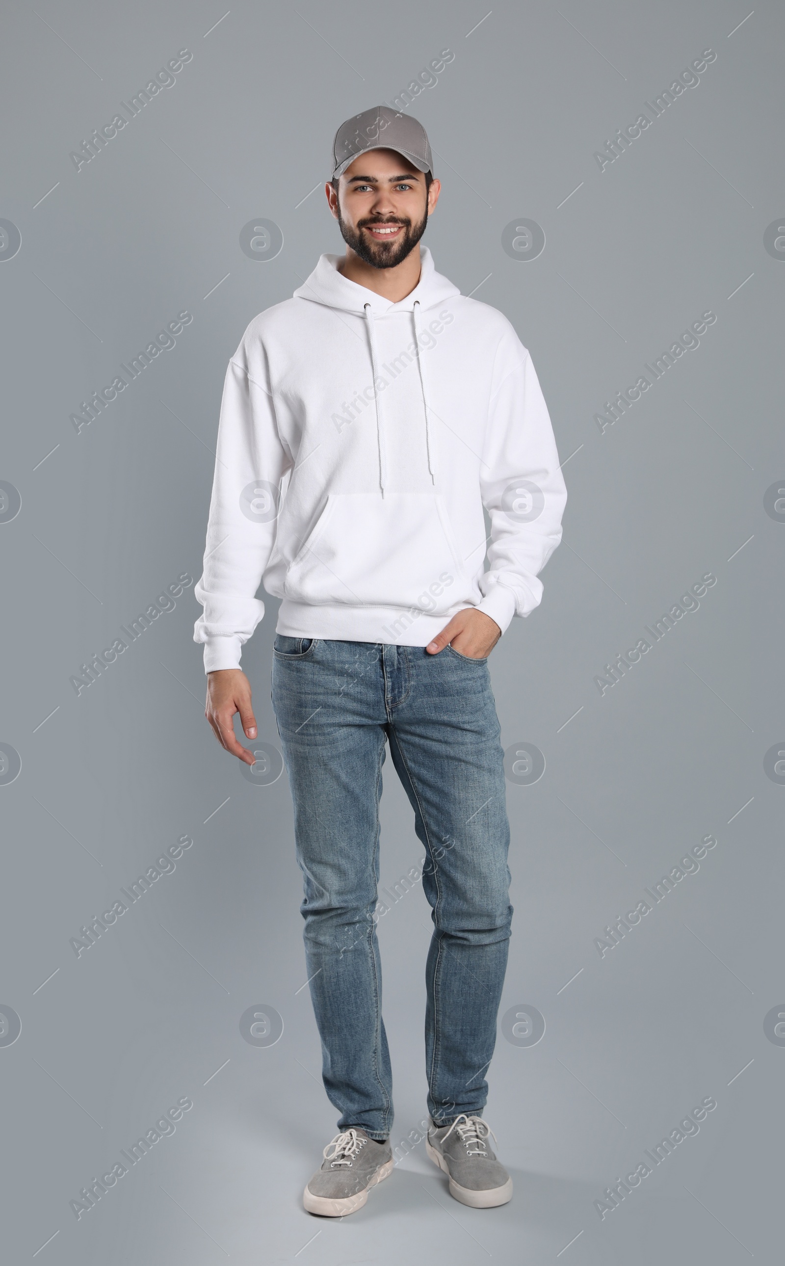 Photo of Full length portrait of young man in sweater on grey background. Mock up for design