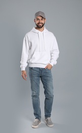 Full length portrait of young man in sweater on grey background. Mock up for design