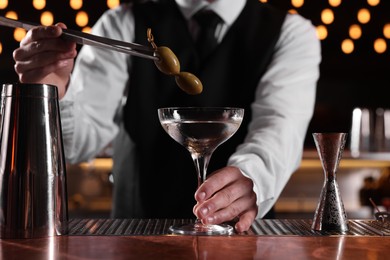 Photo of Bartender preparing fresh Martini cocktail at bar counter, closeup